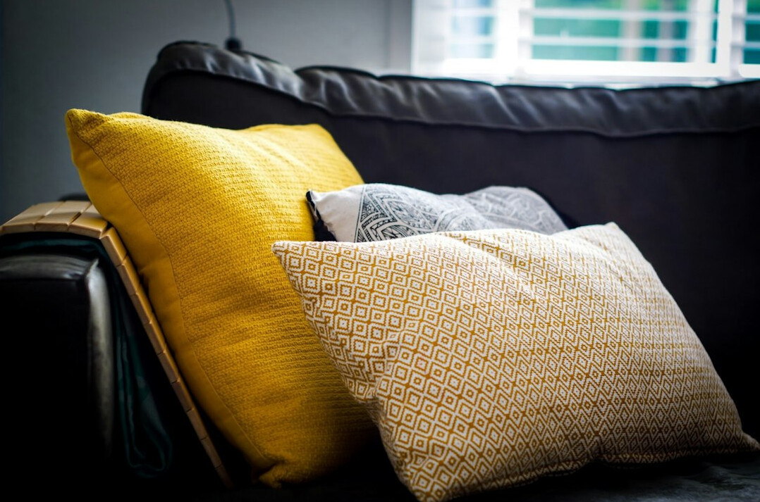 Sofa with several fabric cushions and throws